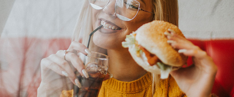 donna che mangia panino e cocacola